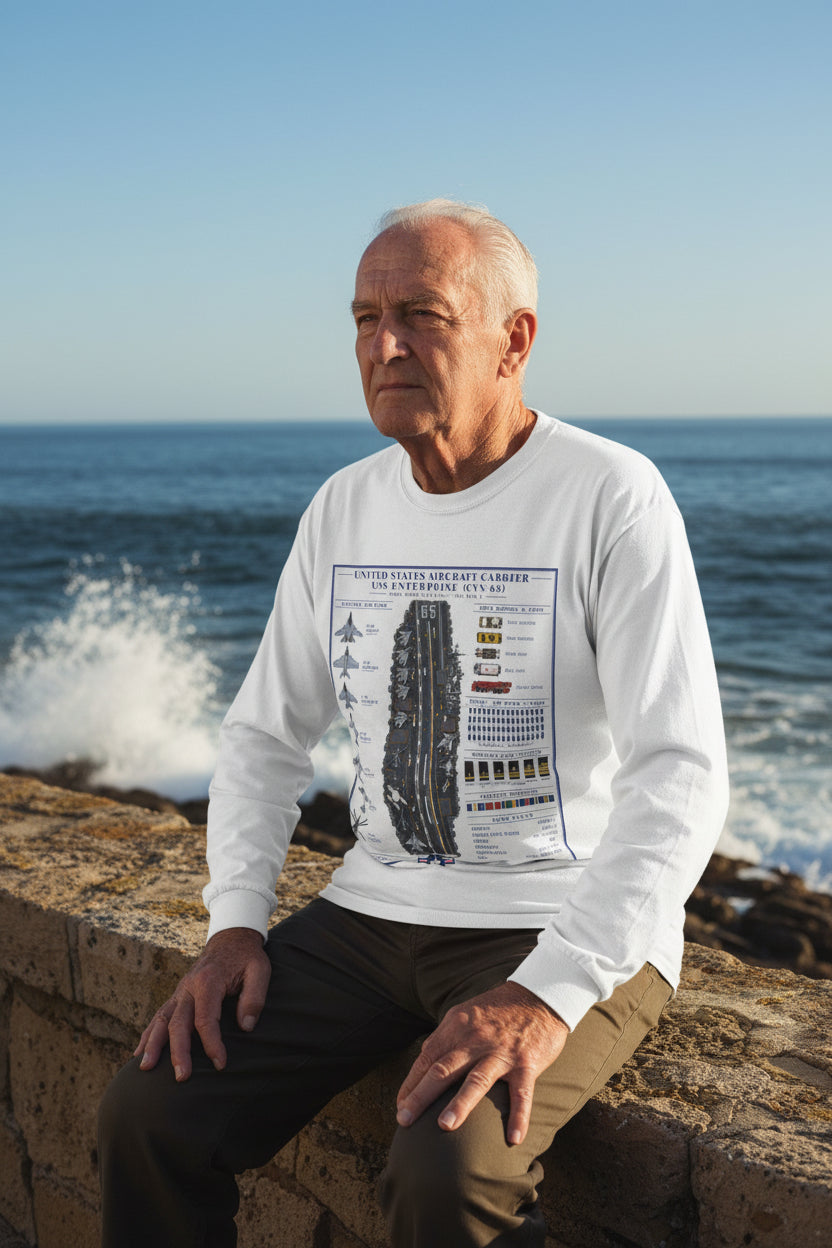 A white long-sleeve crewneck t-shirt featuring a detailed graphic print of the USS Enterprise (CVN-85) aircraft carrier deck and surrounding military insignia on the front.